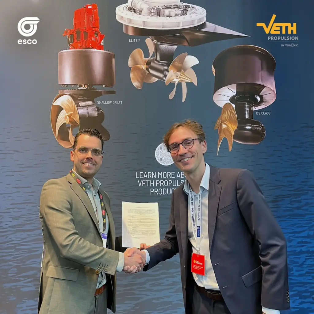 Aufnahme von der Europort 2025: Managing Director Bastiaan van Zuijlekom von Veth Propulsion und Laurent Schmidt, CEO der ESCO Group, bestätigen ihre Partnerschaft mit einem Handschlag. Im Hintergrund sind maritime Antriebslösungen von Veth Propulsion zu sehen.